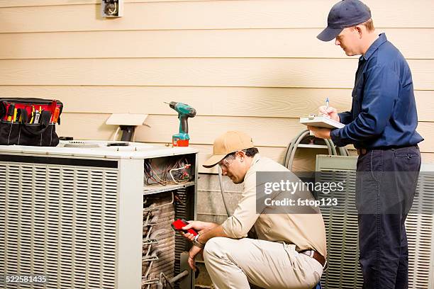 ar-condicionado repairmen trabalho em casa unidade. trabalhadores de colarinho azul. - ventilador imagens e fotografias de stock