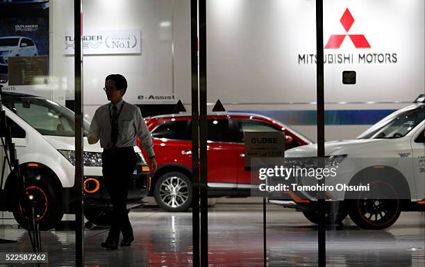 An employee walks past a Mitsubishi Motors vehicles displayed at the company's headquarters on April 20, 2016 in Tokyo, Japan. Mitsubishi Motors...