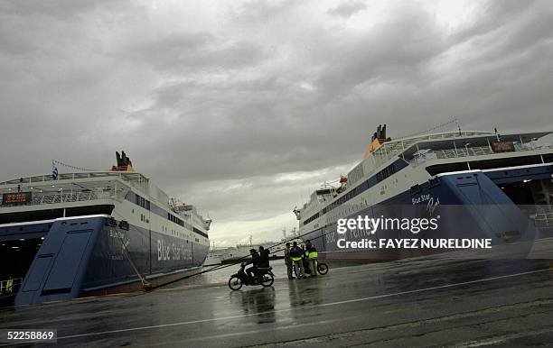 Sea workers and passers by are seen near passenger ferryboats tied at the port of Piraeus, 01 March 2005. Vessels remained in harbour and ferry...