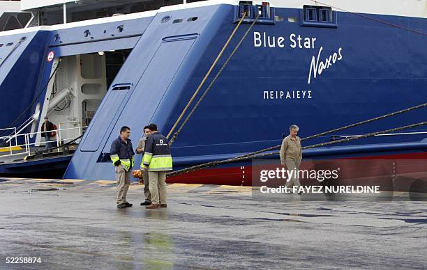 Workers are seen near a passenger ferryboat tied at the port of Piraeus, 01 March 2005. Vessels remained in harbour and ferry services to many of...