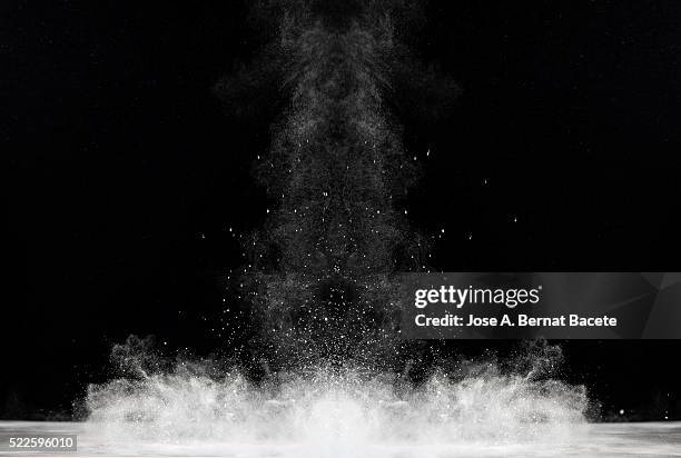 blackground of particles of white powder in ascending movement floating in the air - black blackground stock pictures, royalty-free photos & images