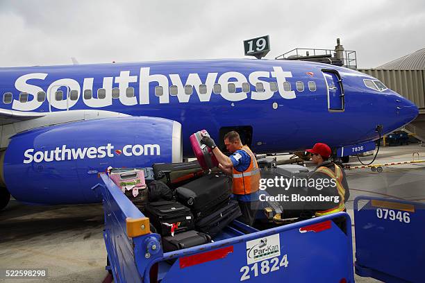 Ground operations employees load baggage onto a Southwest Airlines Co. Boeing Co. 737 aircraft on the tarmac at John Wayne Airport in Santa Ana,...