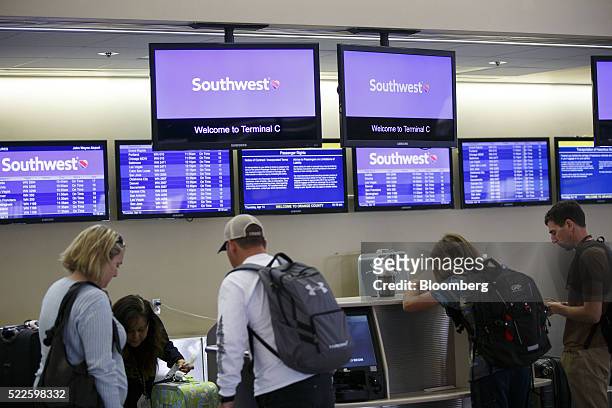 Travelers check-in at the Southwest Airlines Co. Ticket counter inside John Wayne Airport in Santa Ana, California, U.S., on Thursday, April 14,...