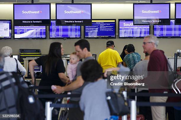 Travelers check-in at the Southwest Airlines Co. Ticket counter inside John Wayne Airport in Santa Ana, California, U.S., on Thursday, April 14,...