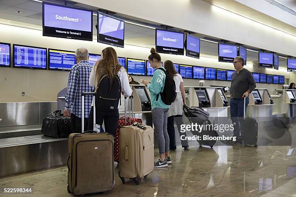 Travelers check-in at the Southwest Airlines Co. Ticket counter inside John Wayne Airport in Santa Ana, California, U.S., on Thursday, April 14,...