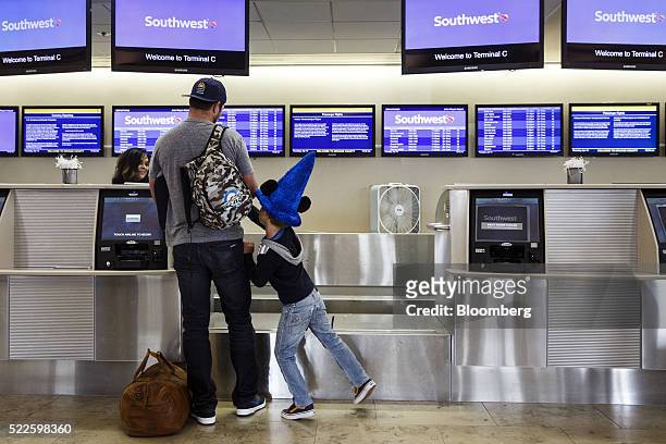 Child wears a Walt Disney Co. Mickey Mouse hat during check-in at the Southwest Airlines Co. Ticket counter inside John Wayne Airport in Santa Ana,...