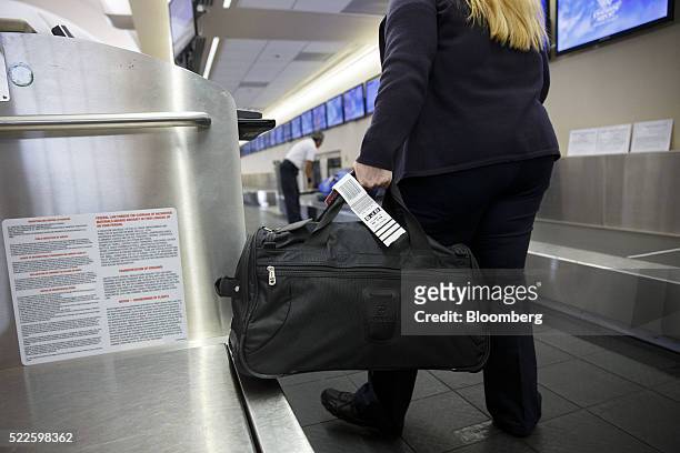 Southwest Airlines Co. Ticketing agent tags a bag for a traveler at John Wayne Airport in Santa Ana, California, U.S., on Thursday, April 14, 2016....