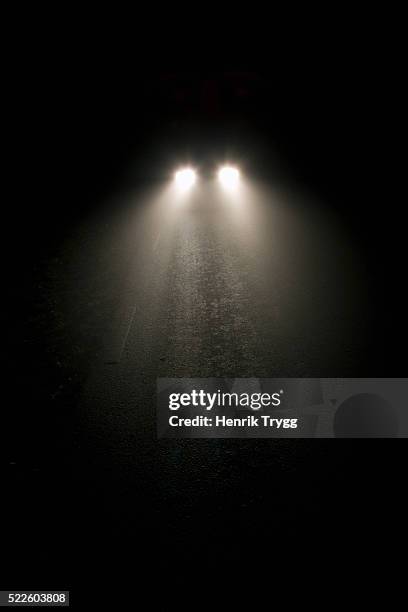 automobile lights on foggy night - image stockfoto's en -beelden