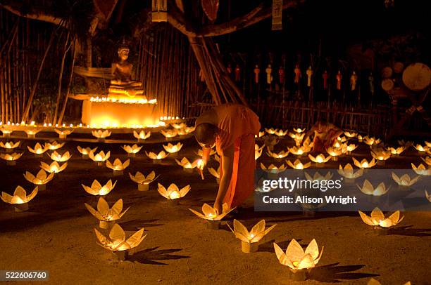 monks lighting candles at loi krathong festival - loi krathong - fotografias e filmes do acervo