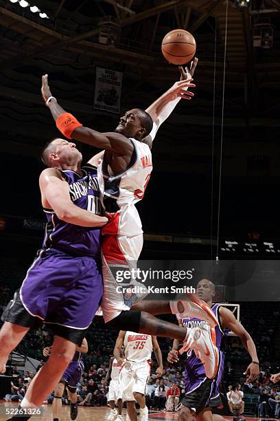 Gerald Wallace of the Charlotte Bobcats gets denied the dunk by a block from Greg Ostertag of the Sacramento Kings on March 1, 2005 at the Charlotte...