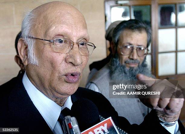 Abdul Waheed Katpar , Pakistani lawyer of Ahmed Saeed Omar - the alleged killer of US reporter Daniel Pearl - is watched by Omar's father Ahmed Saeed...