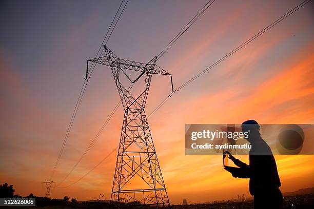 ingénieur en électricité laptopl de travail - poteau électrique photos et images de collection