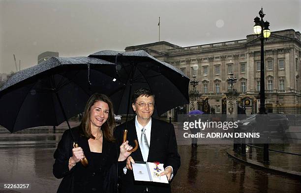 United Kingdom: Chairman and Chief Software architect of Microsoft Bill Gates shows off his honorary knighthood with his wife Melinda outside...