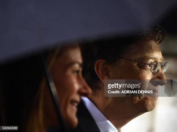 United Kingdom: Chairman and Chief Software architect of Microsoft Bill Gates and his wife Melinda stand beneath an umbrella after he received an...