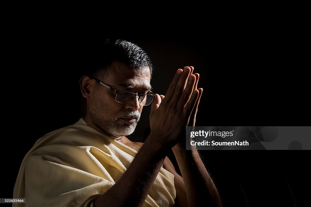 Old Hindu man praying with folded hands