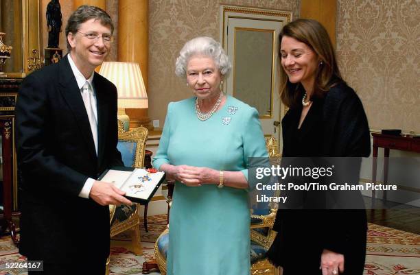 Microsoft founder Bill Gates and his wife Melinda pose for photographs after Gates is awarded an honorary knighthood at Buckingham Palace on March 2,...