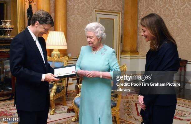 Microsoft founder Bill Gates and his wife Melinda pose for photographer after Gates is awarded an honorary knighthood at Buckingham Palace on March...
