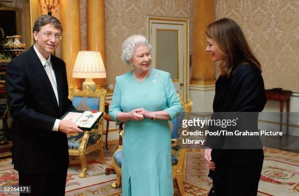 Microsoft founder Bill Gates and his wife Melinda pose for photographs after Gates is awarded an honorary knighthood at Buckingham Palace on March 2,...