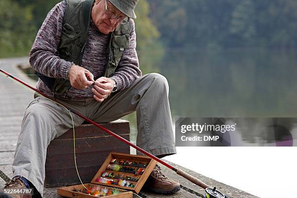 senior man preparing the bait for fishing - vishaak visgerei stockfoto's en -beelden