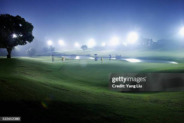 golfing at night in guangdong province - golf caddy stock-fotos und bilder