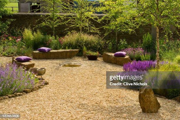 gravel garden with rock seats and wild flowers - rock garden stockfoto's en -beelden