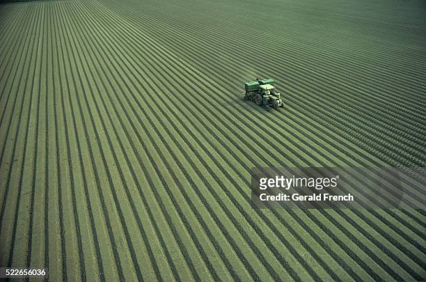 tractor planting crops - campo arato foto e immagini stock