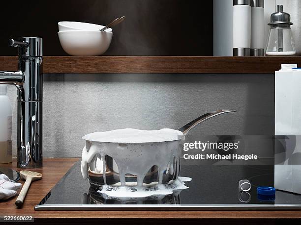 saucepan boiling over on stove - bollente foto e immagini stock