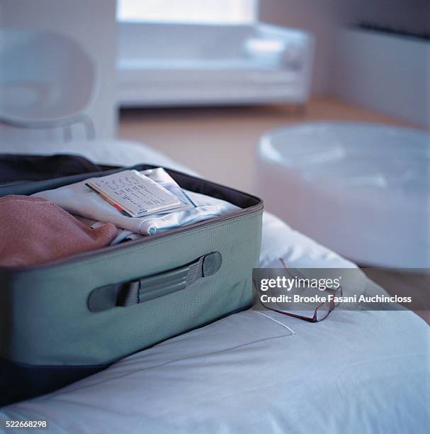 a packed suitcase on a bed - open suitcase stock pictures, royalty-free photos & images