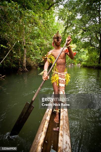 man paddling canoe in papua new guinea - pirogue stock-fotos und bilder