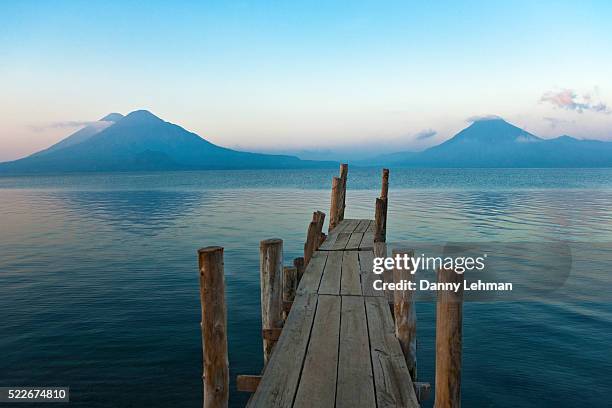 pier on lake atitlan with view of volcanoes - guatemala stock pictures, royalty-free photos & images