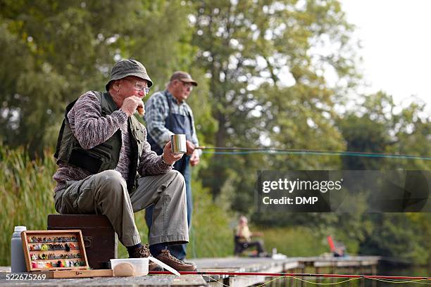 senior fisherman having lunch - fishing tackle box stock pictures, royalty-free photos & images