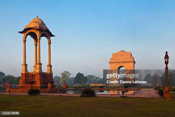 statue canopy with india gate, a national monument. the gate is a massive red sandstone arch and the indian army's tomb of the unknown soldier . - porta da índia imagens e fotografias de stock