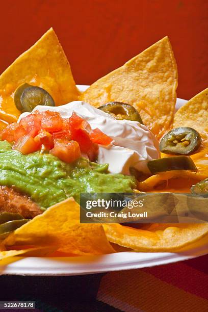 nachos wth guacamole, sour cream and jalapeno peppers - mexican food stock pictures, royalty-free photos & images