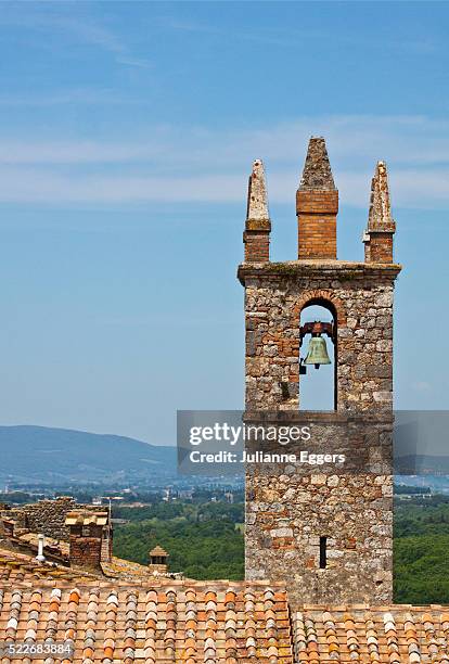 bell tower of the romanesque church of santa maria assuntain in the piazza roma, monteriggioni, tusc - monteriggioni stock pictures, royalty-free photos & images