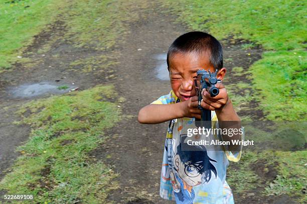 tibetan boy with toy gun - kham stock pictures, royalty-free photos & images