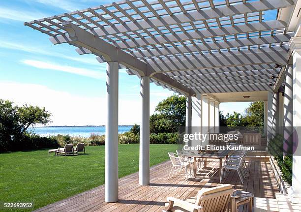 a beach house with pergola and lounge chairs - hamptons stock pictures, royalty-free photos & images