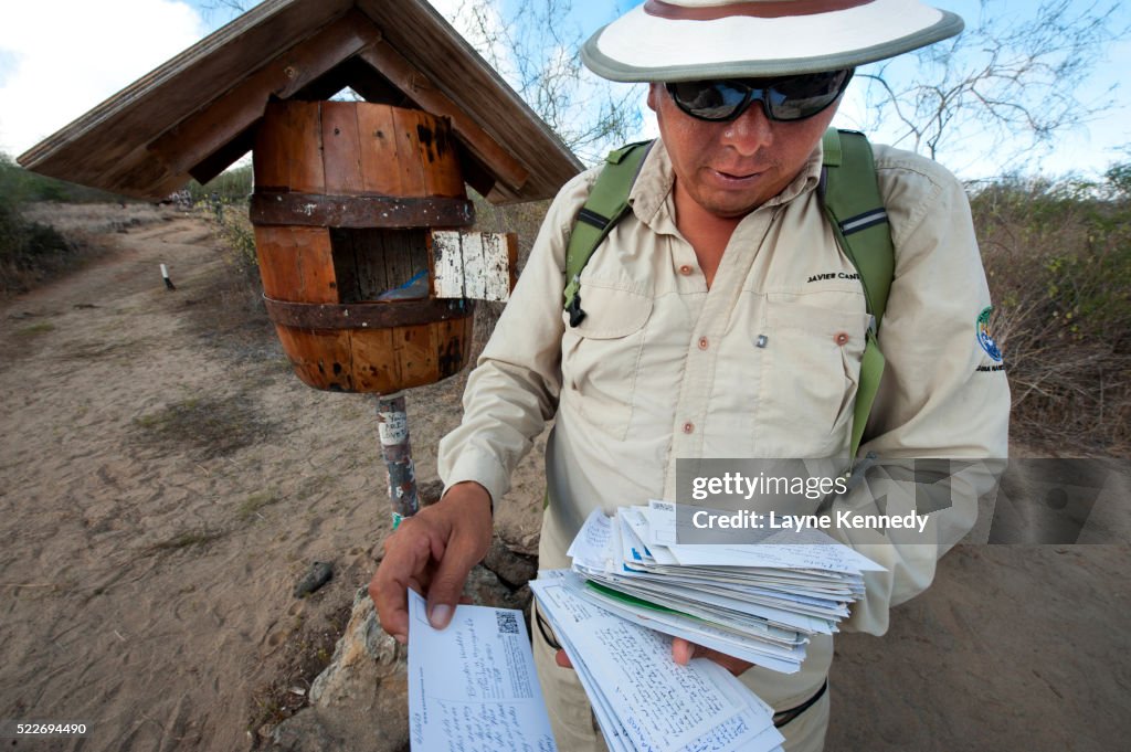 Park Service Guide Javier Cando looks through mail at Floreana Island