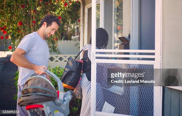 home with baby - mom and dad - guy in car seat stockfoto's en -beelden