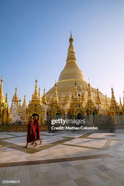 two monks walking near shwedagon paya, myanmar - myanmar culture stockfoto's en -beelden