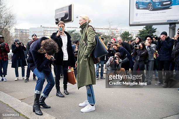 Models Laura Kampman, Marte Mei Van Haaster, and Maggie Maurer carry Celine twisted cabas bags and are surrounded by photographers after the Celine...