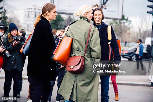 Models Laura Kampman, Marte Mei Van Haaster, and Maggie Maurer carry Celine twisted cabas bags after the Celine show at Tennis Club de Paris on Day 6...