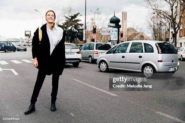 Dutch model Laura Kampman wears an all black outfit with a white button-up top and carries a Celine twisted cabas bags after the Celine show at...