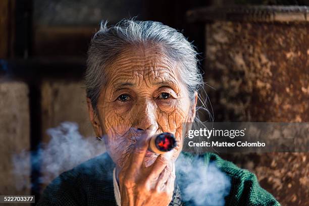 portrait of old burmese woman smoking big cigar - beautiful women smoking cigars fotografías e imágenes de stock