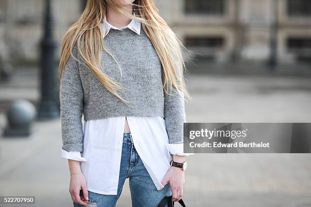 Emma Bonneaud , is wearing Zara red shoes, Mango blue jeans, a Wanted Gina white shirt, an Asos gray pullover, a Daniel Wellington watch, a Zara bag,...