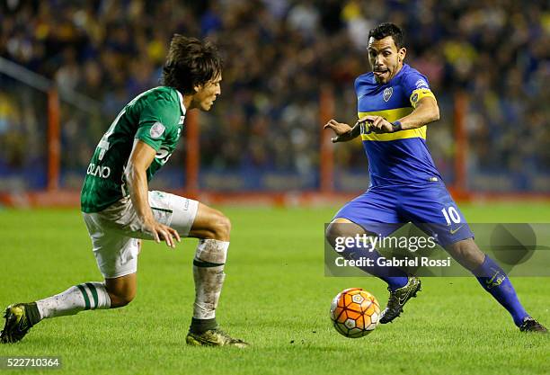 Carlos Tevez of Boca Juniors dribbles past Jhon Jairo Lozano of Deportivo Cali during a match between Boca Juniors and Deportivo Cali as part of Copa...