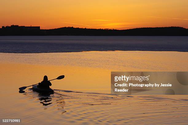 woman kayaking at sunset on half frozen lake - lake mendota stock pictures, royalty-free photos & images