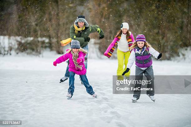 family ice-skating on pond - father and mother with their daughter playing in the snow stock pictures, royalty-free photos & images