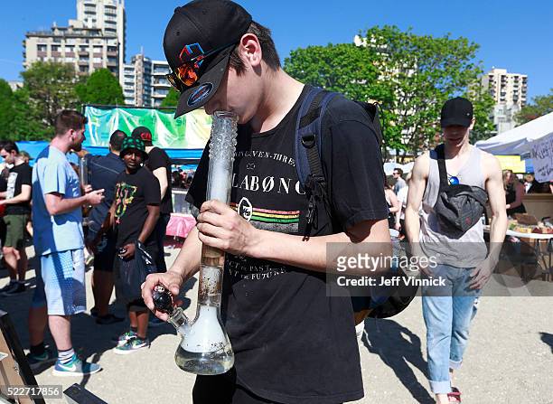 Man smokes a bong as thousands of people gather at 4/20 celebrations on April 20, 2016 at Sunset Beach in Vancouver, Canada. The Vancouver 4/20 event...