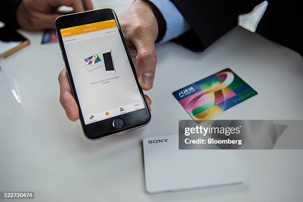 Man demonstrates the O! ePay mobile payment service, operated by Octopus Cards Ltd., a subsidiary of MTR Corp., using an Apple Inc. IPhone and an...