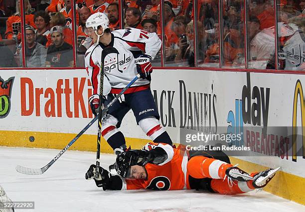 Scott Laughton of the Philadelphia Flyers falls into the boards behind the net against John Carlson of the Washington Capitals in Game Four of the...